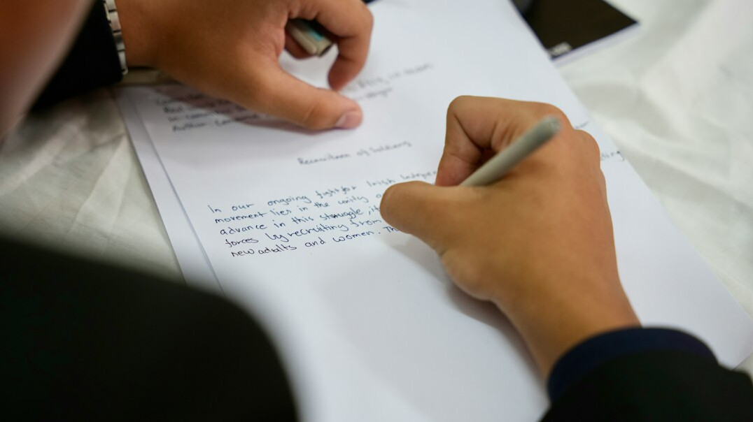 person writing budget on paper